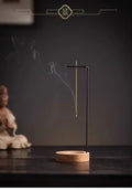 Stillpoint hanging incense holder with round wood-toned base and black upright stand